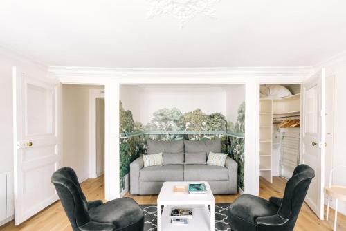 un salon avec un canapé et deux chaises dans l'établissement GuestReady - Incroyable Apt Paris pour 2 dans 7arr, à Paris