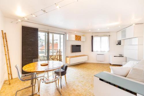 un salon avec une table et un canapé dans l'établissement GuestReady - Apt. Rénové à 15min de Paris, à Issy-les-Moulineaux