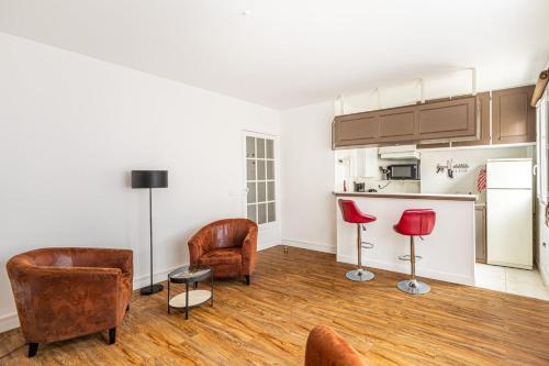 Il comprend un salon avec deux chaises et une cuisine. dans l'établissement GuestReady -Superbe Appartement dans le 14ème Arr., à Paris