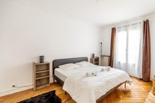 une chambre avec un lit avec deux animaux en peluche dessus dans l'établissement GuestReady -Superbe Appartement dans le 14ème Arr., à Paris