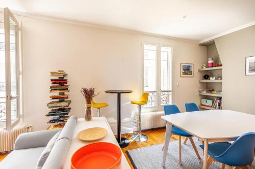 un salon avec une table et des chaises blanches dans l'établissement GuestReady -Appart lumineux près de la Place d'Italie, à Paris