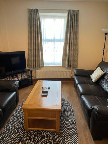 a living room with a couch and a coffee table at A Family Cottage in Tenby in Tenby