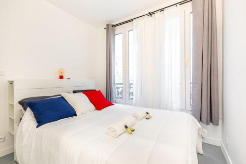 a white bedroom with a large white bed and a window at GuestReady - Patriotic Blank Canvas near Louvre in Paris