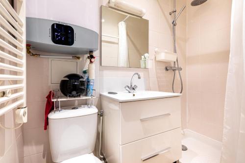 a bathroom with a toilet and a sink and a mirror at GuestReady - Patriotic Blank Canvas near Louvre in Paris