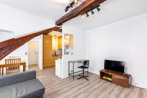 un salon avec un canapé et une télévision dans l'établissement GuestReady - Appartement Cosy au Cœur de Paris, à Paris