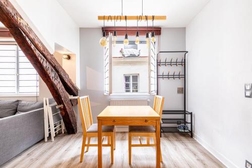 une salle à manger avec une table, des chaises et un canapé dans l'établissement GuestReady - Appartement Cosy au Cœur de Paris, à Paris