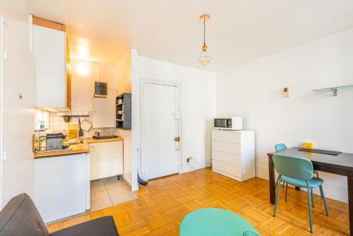 une cuisine avec un bureau et une table avec des chaises dans l'établissement GuestReady - Apt clair et spacieux à Paris !, à Paris