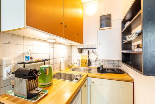 une petite cuisine avec un évier et un micro-ondes dans l'établissement GuestReady - Apt clair et spacieux à Paris !, à Paris