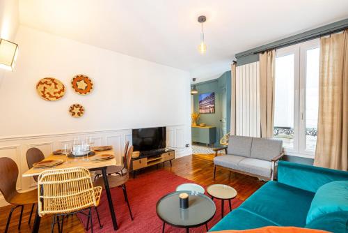 un salon avec un canapé bleu et une table dans l'établissement GuestReady - Appt Élégant près de la Tour Eiffel, à Paris