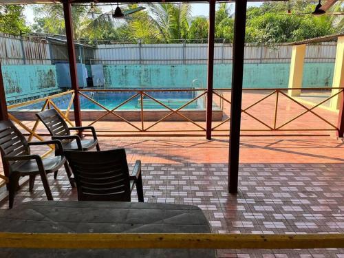 a patio with a table and chairs and a swimming pool at The Hill House on yeoor hills in Thane