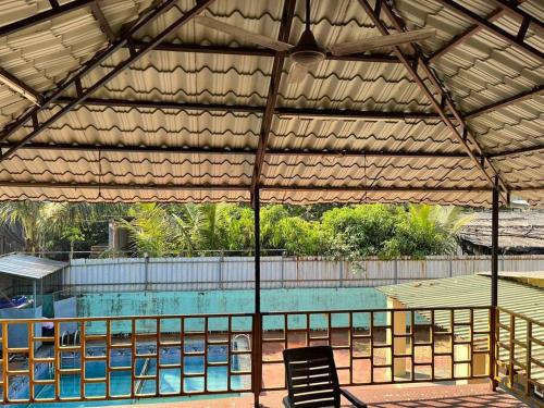 acovered swimming pool with a table and a chair at The Hill House on yeoor hills in Thane
