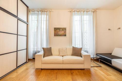 un salon avec un canapé et un lit dans l'établissement GuestReady - Studio chic près du Canal St-Martin, à Paris