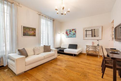un salon avec un canapé blanc et une table dans l'établissement GuestReady - Studio chic près du Canal St-Martin, à Paris