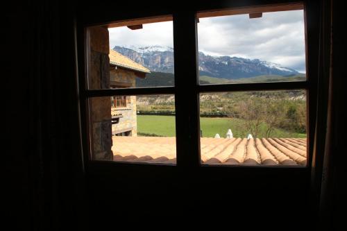 a window looking out at a view of a mountain at Hotel & SPA Peña Montañesa in Aínsa