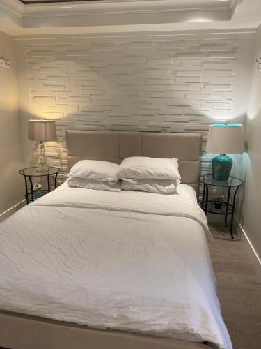 a bedroom with a large white bed with two lamps at 漂亮的卧室 元朗01 in Hong Kong