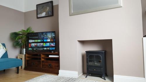 a living room with a fireplace and a tv at Mrs Seeleys House in Choppington
