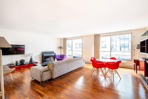 un salon avec un canapé, une table et des chaises dans l'établissement GuestReady - Charmant Appt avec Tour Eiffel Vues, à Paris