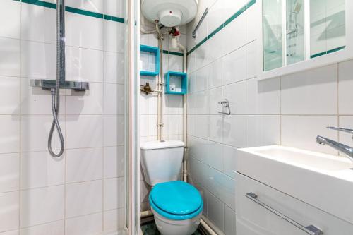 bagno con servizi igienici blu e lavandino di GuestReady - Memorable stay in the suburbs a Issy-les-Moulineaux