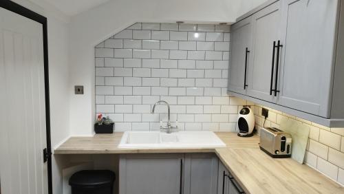 uma cozinha com um lavatório e uma bancada em Mrs Seeleys House em Choppington