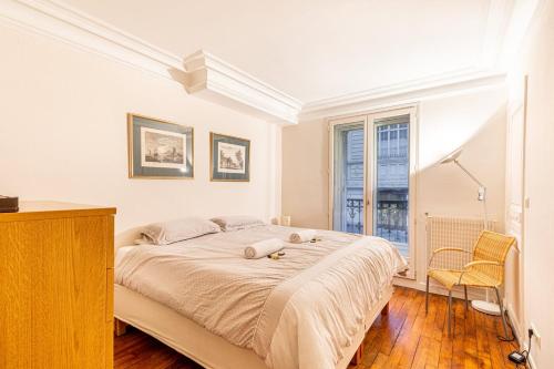 une chambre blanche avec un grand lit et une fenêtre dans l'établissement GuestReady - Superb Appt près du Pathéon, à Paris