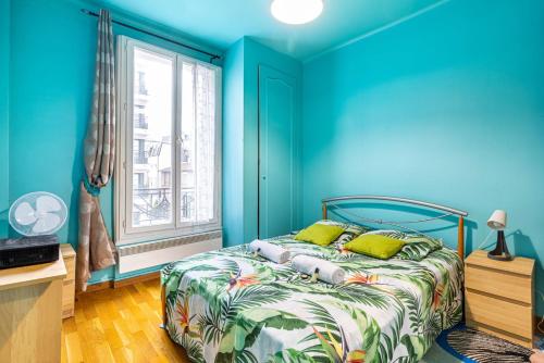 a blue bedroom with a bed and a window at GuestReady - Memorable stay in the suburbs in Issy-les-Moulineaux