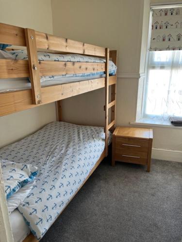a bedroom with a bunk bed and a window at A Family Cottage in Tenby in Tenby