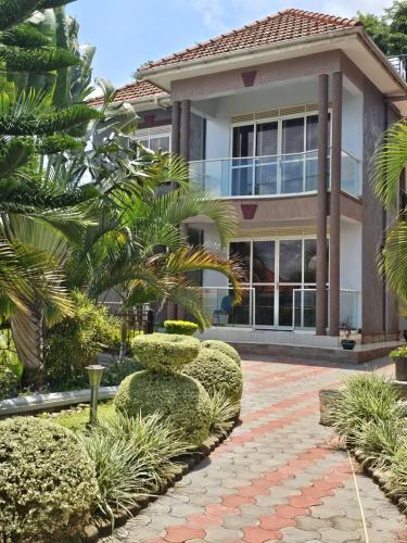 a house with a brick walkway in front of a building at HILLS APARTMENTS in Kampala