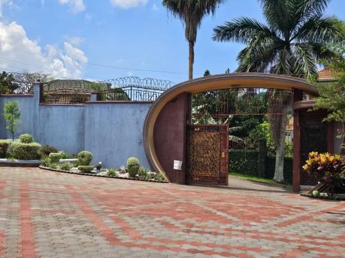 an archway in a courtyard with a garden at HILLS APARTMENTS in Kampala