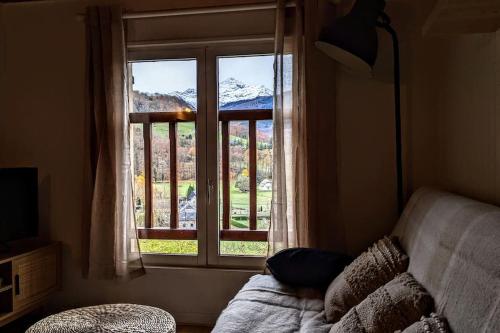 a bedroom with a window with a view of a mountain at Petite maison de montagne in Campan