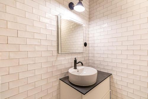 a white bathroom with a sink and a mirror at GuestReady - Cozy Apt Near Square Louise Michel in Paris