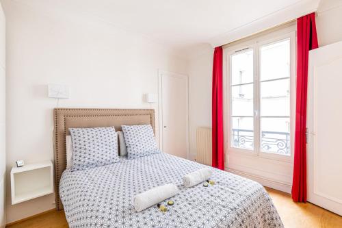 une chambre avec un lit avec des rideaux rouges et une fenêtre dans l'établissement GuestReady - Appartement Élégant dans Le Marais, à Paris
