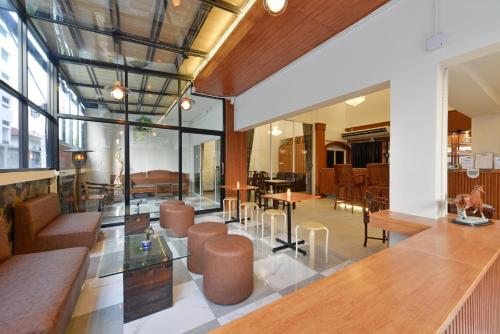 a lobby with chairs and tables in a building at Ratchathewi Hyde Away in Pratunam