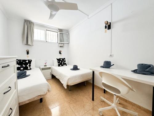 Pokój z 2 łóżkami i biurkiem w obiekcie H4U Apartments - Playa & Dunas w mieście Playa del Ingles