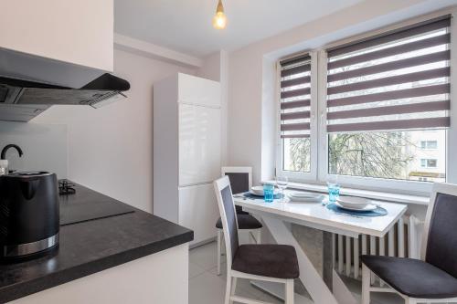cocina con mesa, sillas y ventana en 28 Gdynia Centrum - Apartament Mieszkanie dla 2 os, en Gdynia
