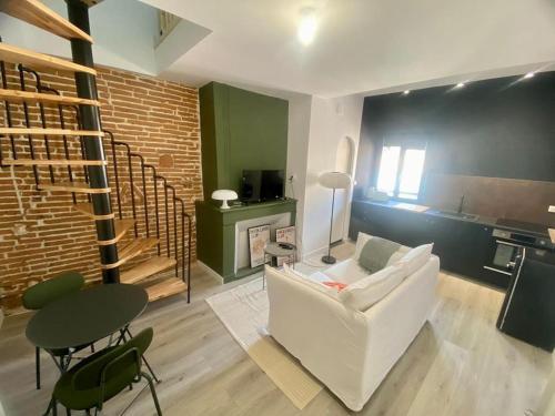 un salon avec un canapé blanc et une table dans l'établissement Le 23, cocon dans le centre historique, à Montauban