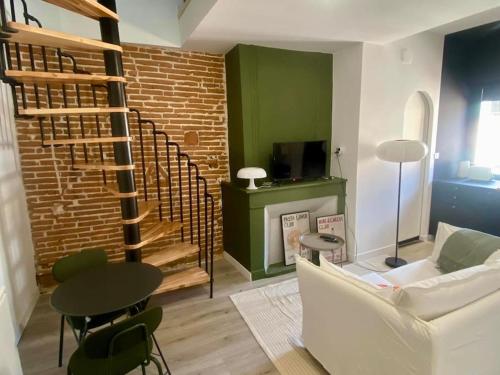 - un salon avec un canapé blanc et un mur en briques dans l'établissement Le 23, cocon dans le centre historique, à Montauban