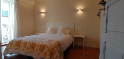 1 dormitorio con 1 cama con sábanas blancas y ventana en Hostal Camponaraya, en Camponaraya