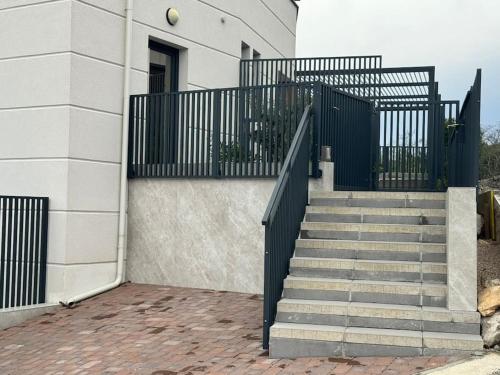 a stairway with a black railing and a building at Panorama Penthouse Punat in Punat