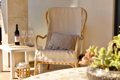 a chair with a towel on it next to a table with wine glasses at Apartamento moderno perto da marina e da praia in Lagos