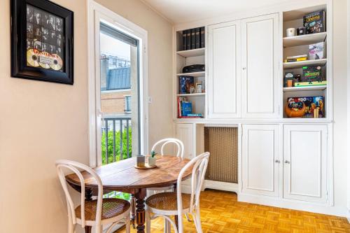 une salle à manger avec une table et des chaises et une fenêtre dans l'établissement GustReady - Charmant studio moderne dans le 14e, à Paris