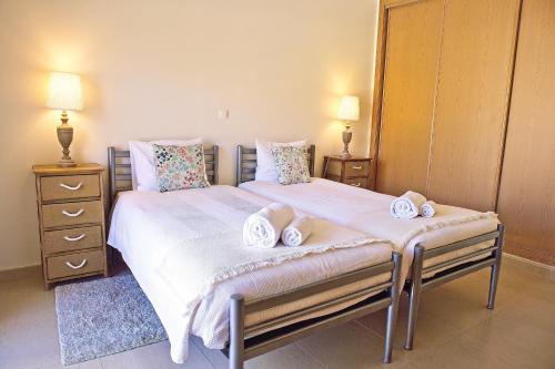 a bedroom with two beds and two lamps and a mirror at Apartamento moderno perto da marina e da praia in Lagos