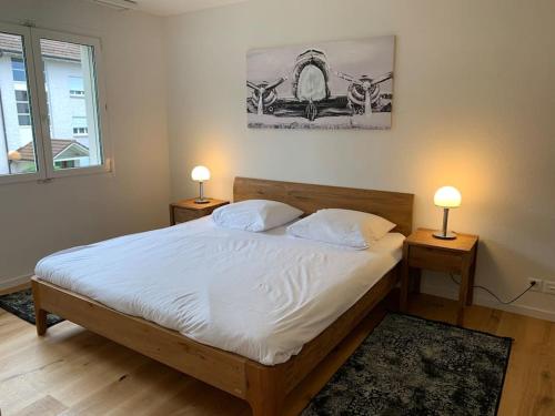 a bedroom with a bed with two lamps on two tables at Modern one bedroom flat close to the city - Bass1 in Bassersdorf