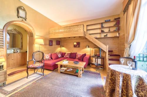 - un salon avec un canapé rouge et un escalier dans l'établissement GuestReady - Bel apt près de l'Arc de Triomphe, à Paris