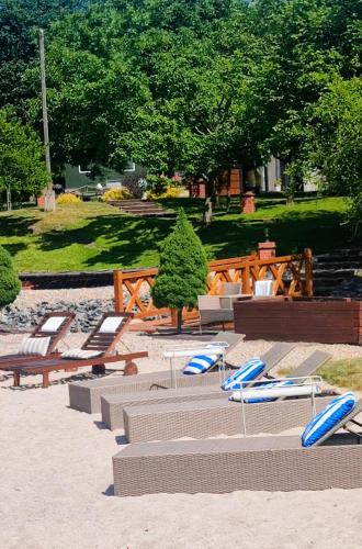 a group of lounge chairs and lounge chairs in a park at Dom dla dwojga w Starym Młynie w Brzeźnicy in Brzeźnica