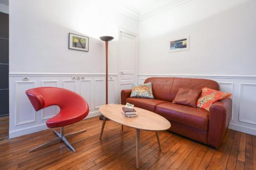 - un salon avec un canapé et un fauteuil rouge dans l'établissement GuestReady - Appt lumineux dans le Quartier Latin, à Paris