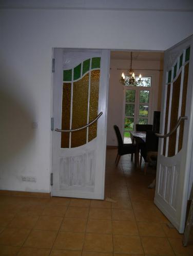 a room with a door and a dining room with a table at Ferienwohnung im Neubauernweg 3 in Hoppegarten
