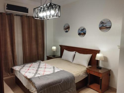 a bedroom with a bed and a chandelier at Blue Bay Asia Ain Elsokhna in Ain Sokhna