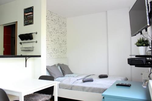 a small room with a bed and a desk at Labo Apartment Karmelicka in Warsaw