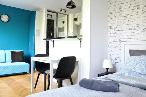 a bedroom with a bed and a table and chairs at Labo Apartment Karmelicka in Warsaw