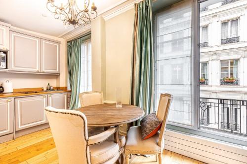 une salle à manger avec une table et des chaises et une fenêtre dans l'établissement GuestReady - Lux Studio - In Le Marais, à Paris